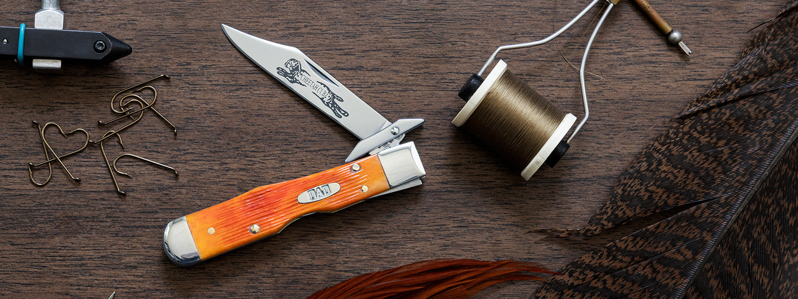 2026 Father's Day Case knife with orange handle and metal blade on a wooden surface.