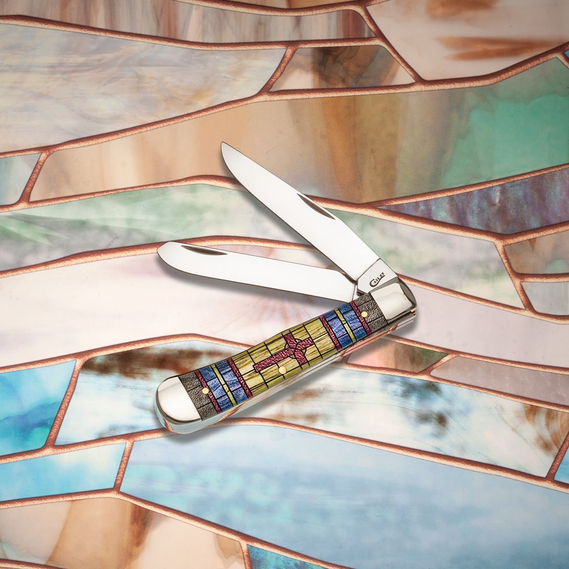 Smooth Natural Bone Stained Glass Trapper Cross in Jewel Box Knife Front View on a Stained Glass Background
