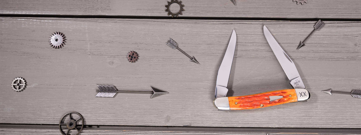 Case knife - Heritage Jig Tequila Sunrise Bone Muskrat on a wooden surface with small tools around it