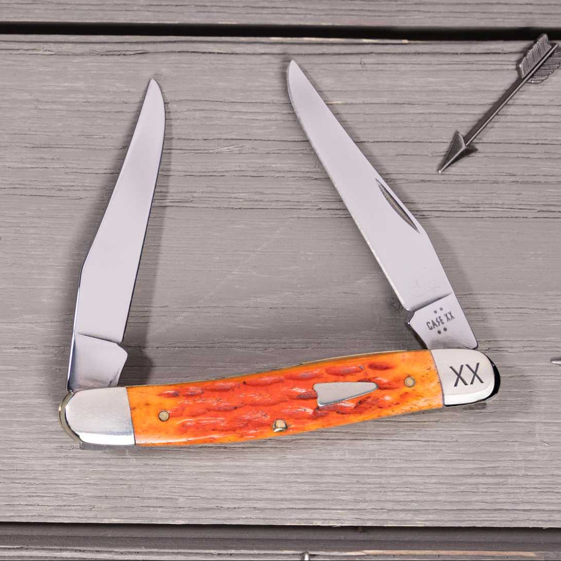 Case knife - Heritage Jig Tequila Sunrise Bone Muskrat on a wooden surface