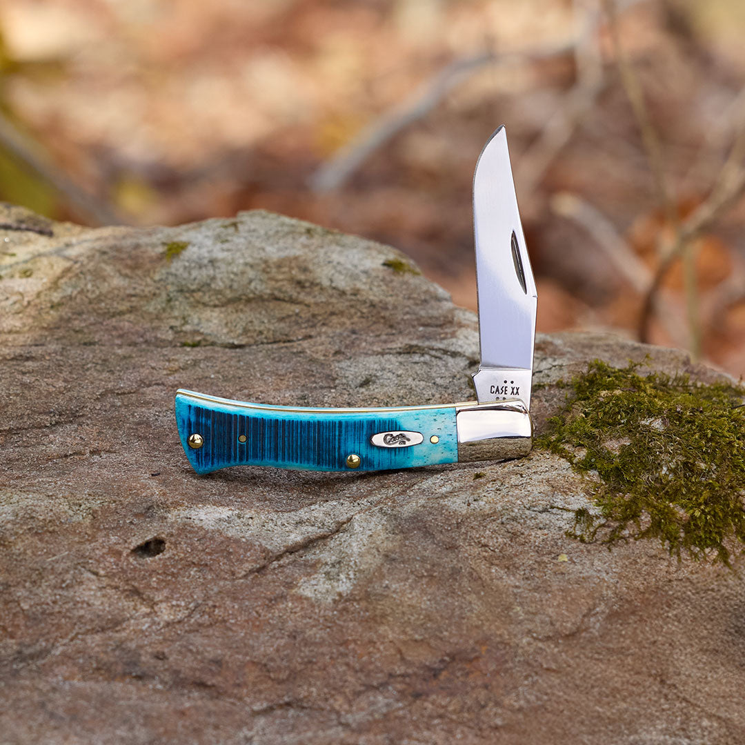 Pocket knife with blue handle on a rock