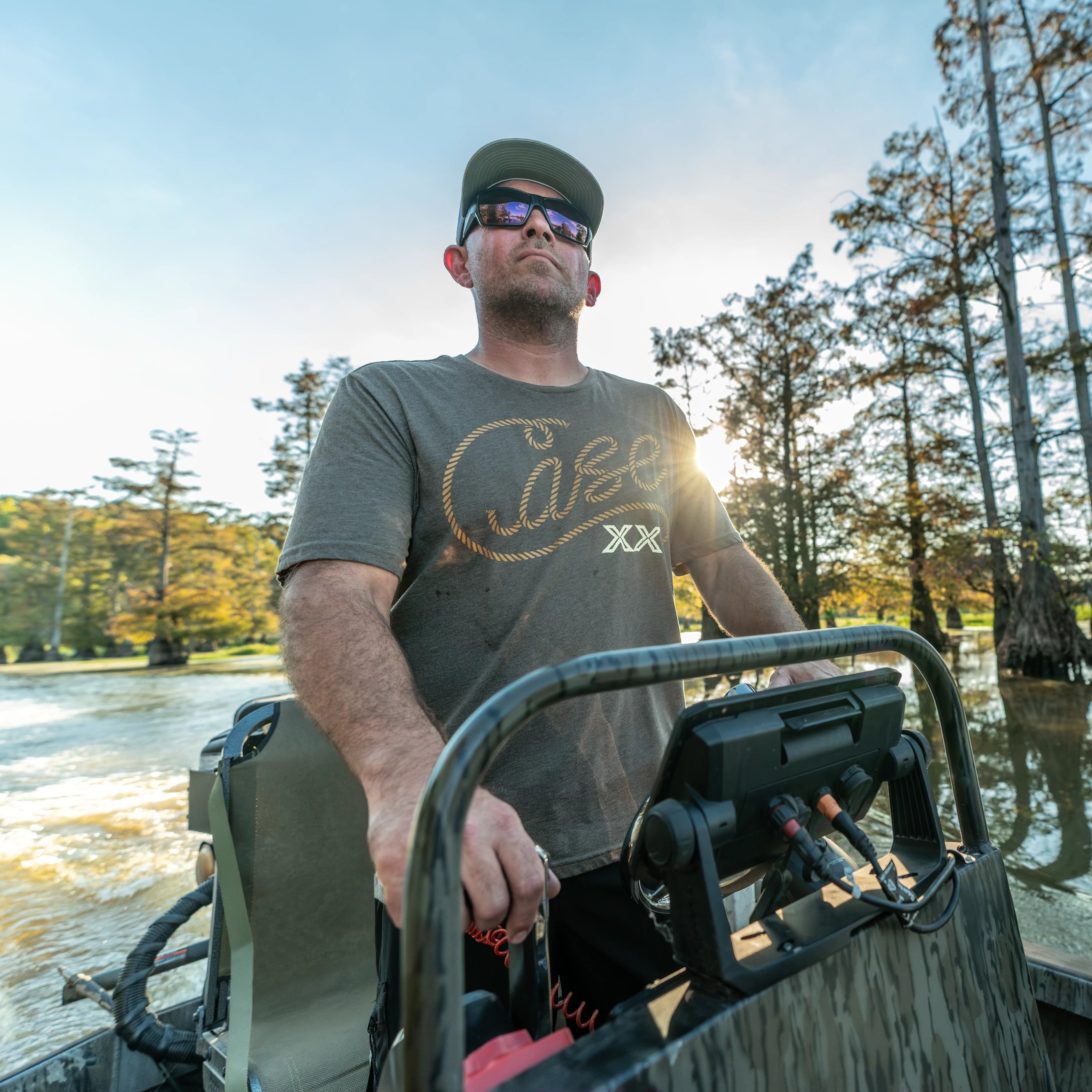 Man driving a boat wearing a Case Knives t-shirt.