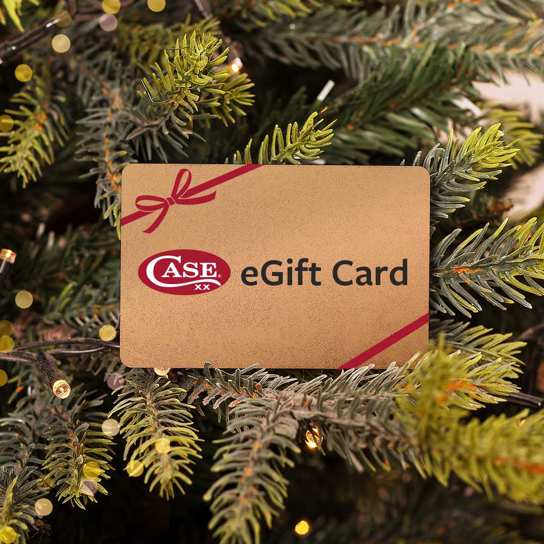 A Case eGift Card with a red ribbon graphic and the CASE logo, placed among green Christmas tree branches with warm bokeh lights.