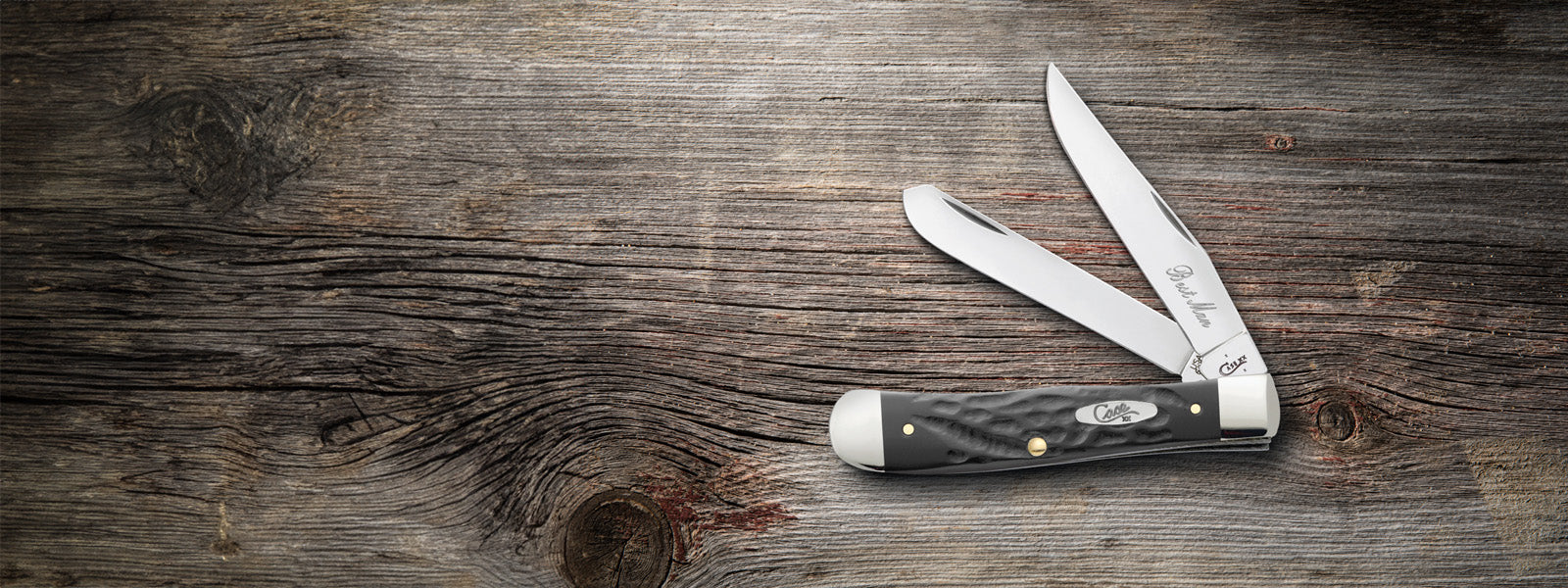 Custom engraved gray Case knife with two blades open on a wooden surface