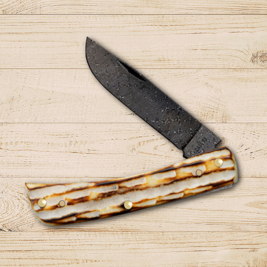 Deep Canyon Burnt Natural Bone knife on a wood plank background.