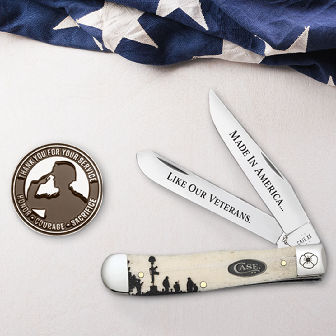 Veteran's Day Commemorative knife with engraved text on a white surface with an American flag in the background.