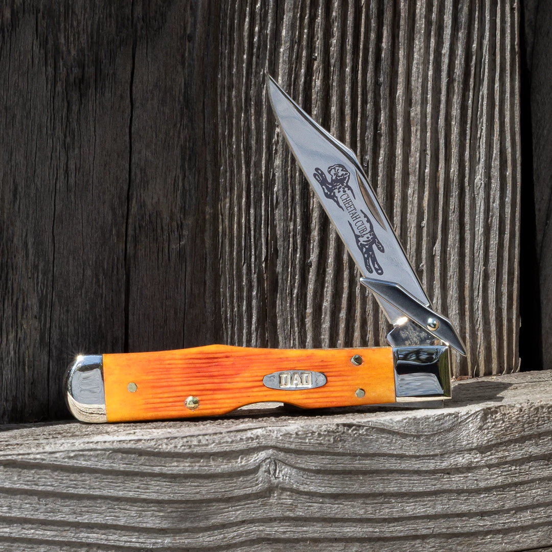Lifestyle image ofFather's Day Barnboard Jig Tequila Sunrise Bone Cheetah® Cub standing on a wooden railing while open