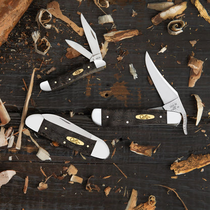 Smooth Black Curly Oak Wood Knives Front View on a Wooden Background Covered in Leaves