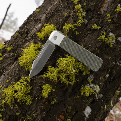 Smooth OD Green Canvas Micarta® Longhouse® On a Tree Stump