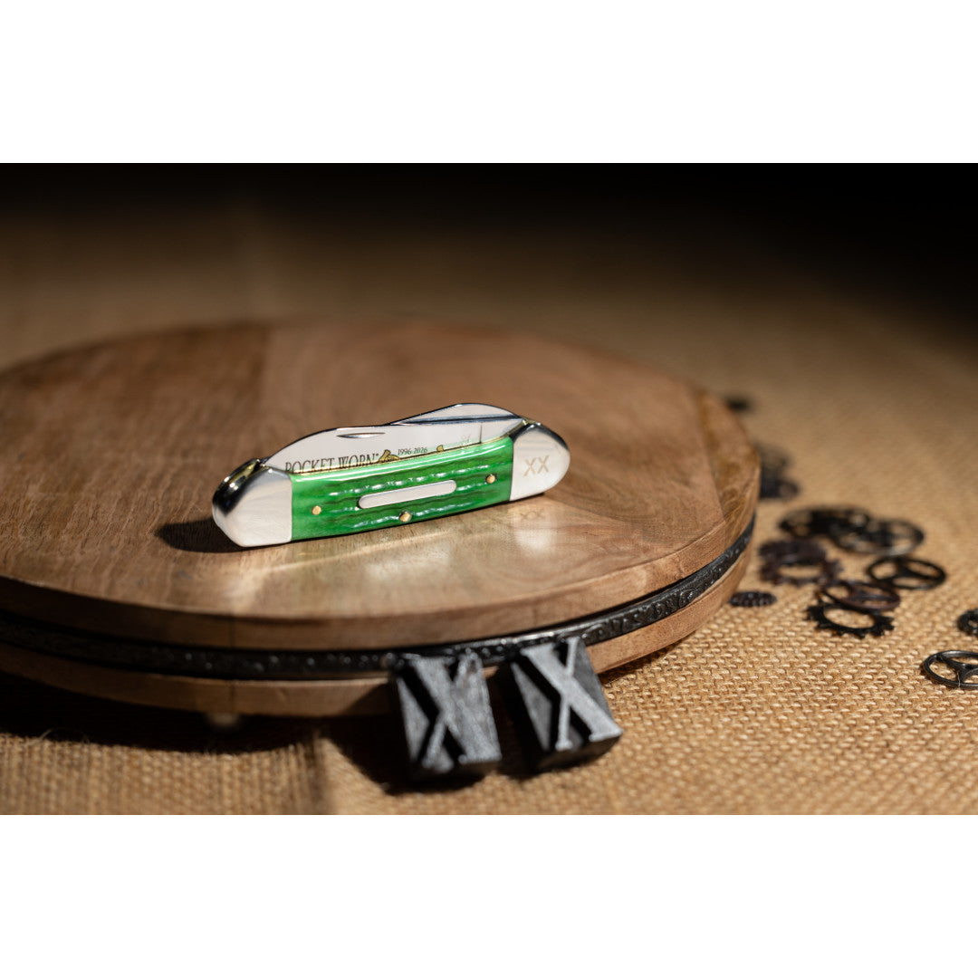 Pocket Worn® Second Cut Jigged Bright Green Bone Canoe sitting on a turnstile with two X stamps in front.