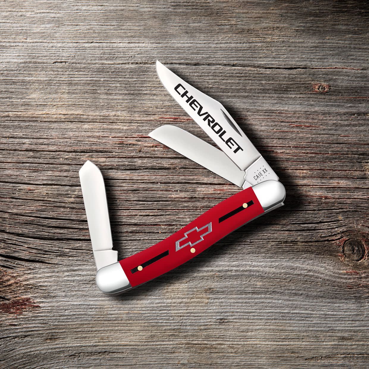 Chevrolet® Embellished Smooth Red Synthetic Stockman Knife on wooden background
