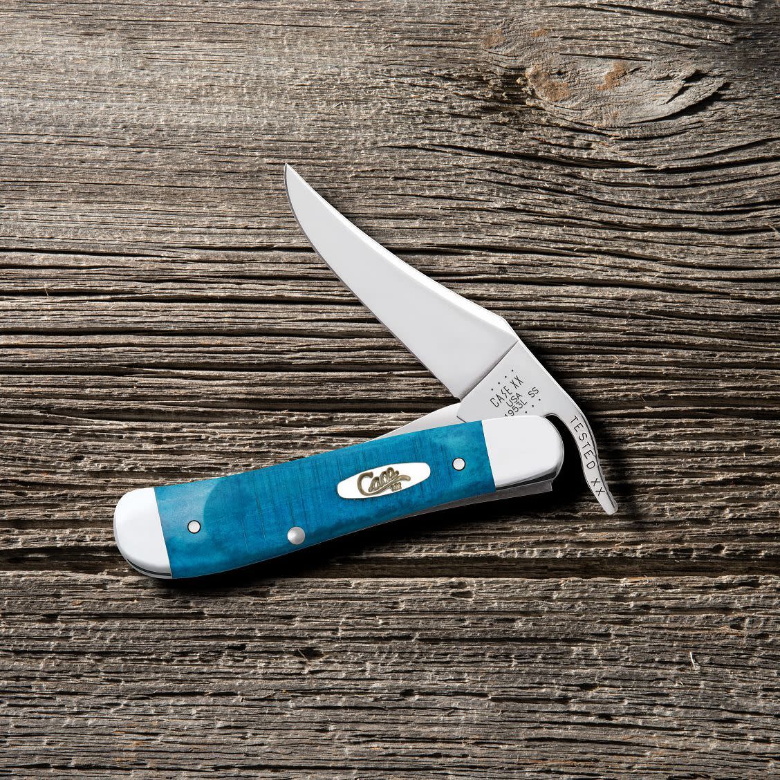 Sawcut Jig Caribbean Blue Bone Russlock® Knife on Wooden Background