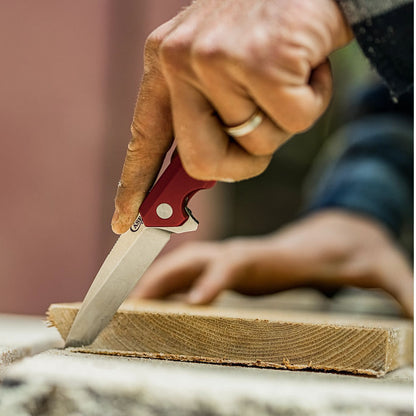 Anodized Aluminum Red Kinzua®open showing the tanto blade cutting wood