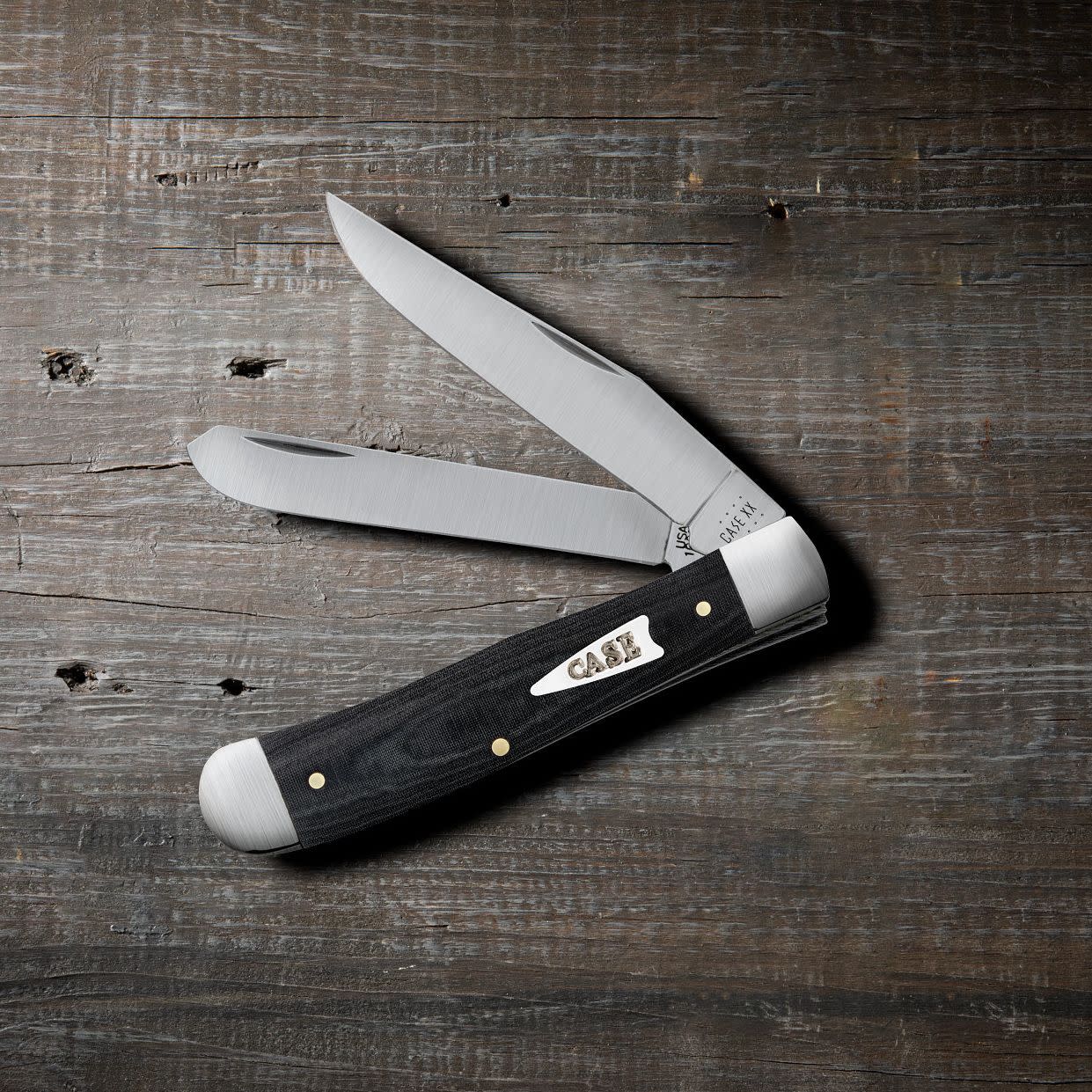 Smooth Black Micarta® Trapper Knife on Wooden Background