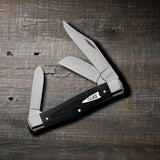 Smooth Black Micarta® Large Stockman Knife on Wooden Background